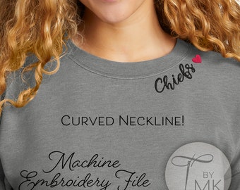 May include: Gray sweatshirt with a curved neckline and a small red heart embroidered on the right shoulder. The text "Chiefs" is embroidered in black below the heart. The text "Machine Embroidery File" is written in cursive below the neckline. The text "©2023 Threaded by Mary Kaye" is written in black below the embroidery file text. The text "BY MK" is written in black in a circle with a needle and thread design.