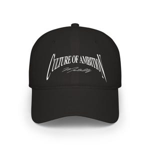 Può includere: Un cappellino da baseball nero con testo ricamato in bianco sul pannello frontale. Il testo recita Culture of Ambition in un grande carattere serif arcuato, con la parola Mentality scritta sotto in un carattere corsivo più piccolo.