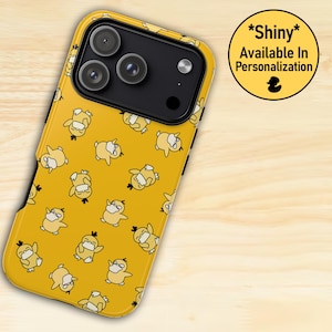 Puede incluir: Funda de teléfono amarilla con un patrón repetido de personajes de patos de dibujos animados. La funda tiene un módulo de cámara negro y un acabado brillante. Un gráfico circular indica que la funda está disponible para personalización.