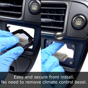 May include: A black plastic car radio installation kit with four gold screws. The kit is being installed into a black car dashboard. The image shows the installation process with the text "SNAP" in a speech bubble.