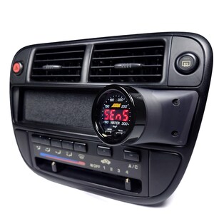 May include: A black car dashboard with a digital water temperature gauge mounted to the right of the air vents. The gauge reads "SE05" and has a range of 100 to 300 degrees Fahrenheit. The gauge is labeled "WATER" and has a "PEAK" indicator.