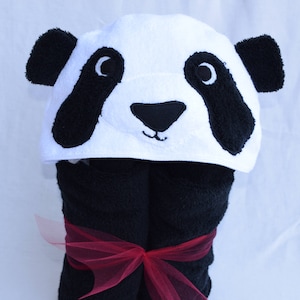 May include: Black and white panda hooded towel with a red ribbon. The towel is made of soft, absorbent material and is perfect for bath time.