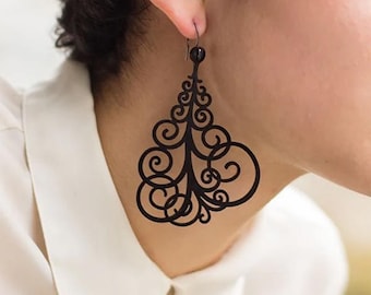 May include: Black dangle earrings with a delicate, intricate design resembling a stylized tree with swirling branches. The earrings are made of a lightweight material and have a black bead at the top.