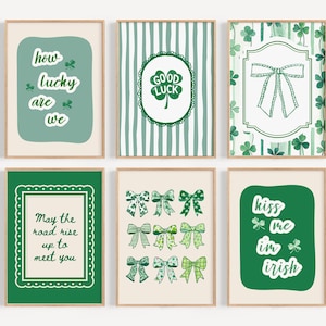 May include: Six framed art prints with St. Patrick's Day themes. The prints feature green and white designs, including shamrocks, bows, and text like "How lucky are we" and "Kiss me I'm Irish."
