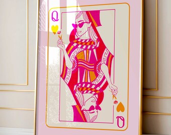Puede incluir: Una impresión enmarcada en rosa y dorado de una carta de la Reina de Corazones. La Reina lleva gafas de sol y una corona y sostiene una flor. La carta está sobre un fondo rosa.