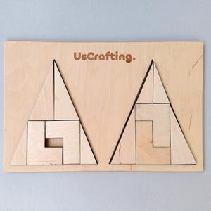 May include: A rectangular light-colored wooden board featuring the text UsCrafting. at the top center. The board contains two large triangle-shaped puzzles made of smaller wooden geometric pieces, each arranged to form a complete triangle shape.