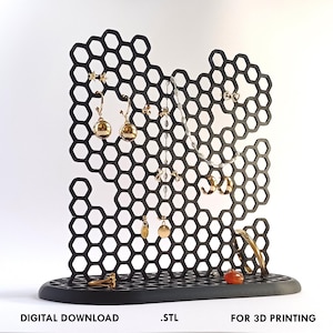 Könnte beinhalten: Schwarzer, wabenförmiger Schmuckständer zum 3D-Druck. Der Ständer verfügt über verschiedene Fächer zum Aufbewahren von Ohrringen, Halsketten und Armbändern. Der Ständer ist so konzipiert, dass er in einem Stück gedruckt werden kann.