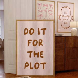 Può includere: Un poster a strisce rosa e bianche con il testo "DO IT FOR THE PLOT" in lettere marroni.
