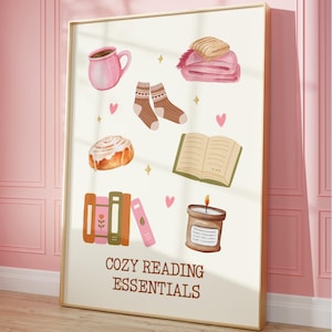 May include: A white poster with the text "Cozy Reading Essentials" in brown lettering. The poster features illustrations of a cup of coffee, a book, a candle, a cinnamon roll, a blanket, and a stack of books.