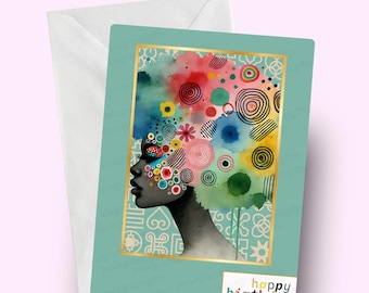 May include: A teal card with a gold border featuring a watercolor illustration of a woman with colorful circles and swirls in her hair. The text "happy birthday" is printed in colorful letters at the bottom of the card.
