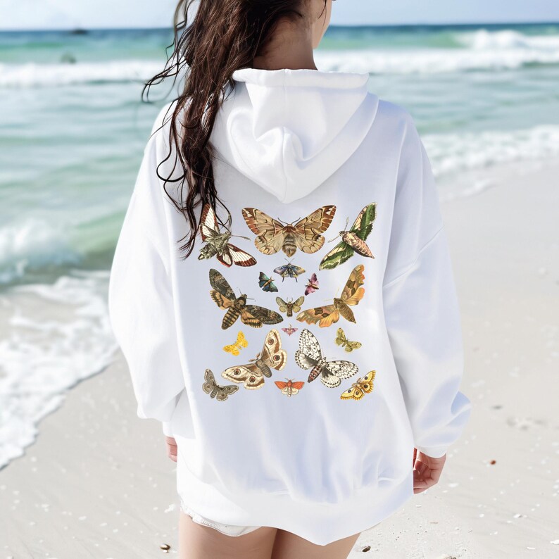 May include: White hoodie with a graphic print of various butterflies in shades of brown, green, and yellow on the back.