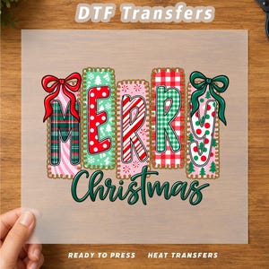 May include: A DTF transfer sheet featuring the text Merry Christmas. The letters are stylized with various patterns including red and green plaid, polka dots, candy cane stripes, and pine trees, accented by red and green bows at the top.