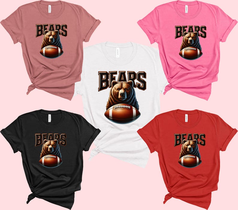 May include: Five t-shirts in different colors, each featuring a brown bear holding a football with the word "BEARS" in large letters above the bear. The shirts are pink, white, black, red, and brown.