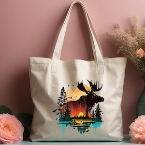 May include: A white canvas tote bag with a silhouette of a moose standing in front of a sunset landscape. The moose is black and the landscape is a gradient of orange, yellow, and blue. The bag has two black handles.