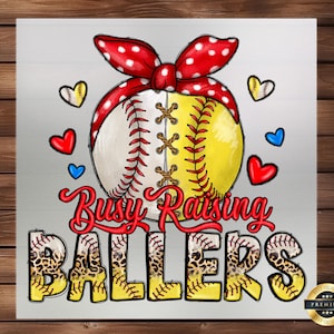 May include: A white and yellow softball with red, white, and black stitching is surrounded by a red, white, and black bow. The text "Busy Raising Ballers" is written in red, white, and black letters. Five softball-shaped objects with a leopard print design are below the text.