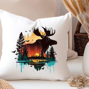 May include: White throw pillow with a colorful graphic print of a moose standing in a forest with a sunset in the background. The moose is silhouetted against the sunset and the forest is made up of trees and bushes. The graphic is surrounded by a blue and green paint splatter effect.