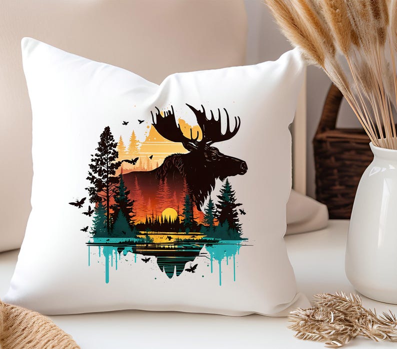May include: White throw pillow with a colorful graphic print of a moose standing in a forest with a sunset in the background. The moose is silhouetted against the sunset and the forest is made up of trees and bushes. The graphic is surrounded by a blue and green paint splatter effect.