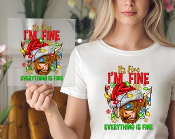 Op de afbeelding: Een heldere vierkante afbeelding met een Highland-koe met een kerstmuts en kerstverlichting. De tekst luidt "It's fine, I'm fine, Everything is fine" in rood en groen. De koe heeft bruine vacht.