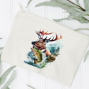 May include: A cream-coloured zipped pouch featuring a watercolour illustration of a deer with large antlers, holding a fish in its mouth. The artwork includes elements of water and a mountain landscape.