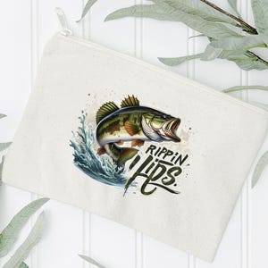 Może przedstawiać: Biała pł&oacute;cienna kosmetyczka z zamkiem błyskawicznym z ilustracją zielonego, brązowego i pomarańczowego okonia i tekstem "Rippin' Lips".