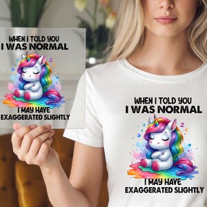 May include: A white t-shirt with a colorful unicorn graphic and the text "When I told you I was normal I may have exaggerated slightly".