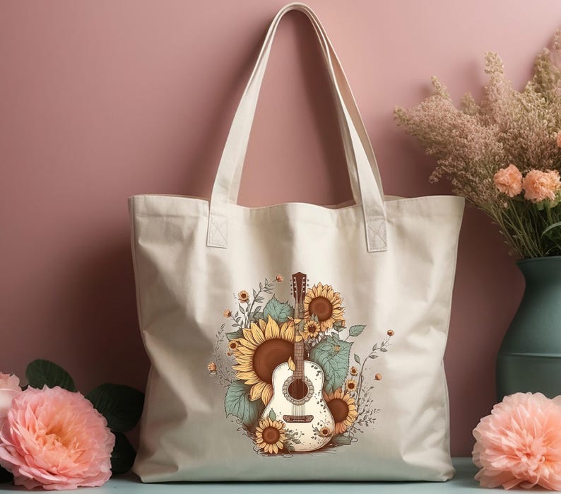 May include: A white canvas tote bag with a design of a guitar surrounded by sunflowers. The bag has brown straps.