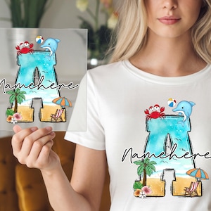 May include: A clear acrylic block featuring a beach-themed design with the letter "A" in turquoise. The design includes a red crab, a blue dolphin, a palm tree, and the text "Namehere".