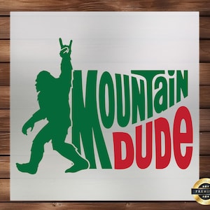 May include: Green and red graphic design with the text "Mountain Dude" and a silhouette of a Bigfoot with a rock and roll hand gesture.