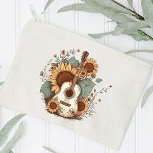 May include: A white canvas makeup bag with a floral design featuring a white acoustic guitar with sunflowers and green leaves.