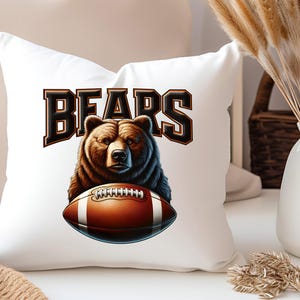 May include: White pillow with a brown bear holding a football. The text "BEARS" is printed in black above the bear.