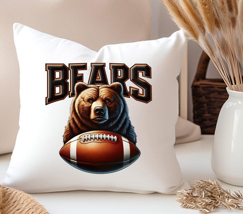 May include: White pillow with a brown bear holding a football. The text "BEARS" is printed in black above the bear.