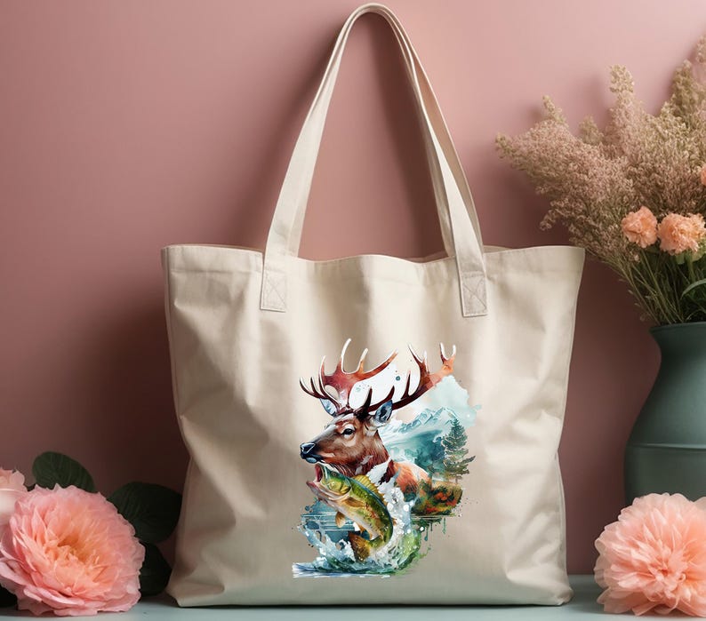 May include: A beige canvas tote bag with a watercolour illustration of a deer with large antlers, a fish, and a mountain scene. The bag has two handles and is suitable for carrying various items.