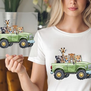 May include: A green jeep illustration with a giraffe, tiger, leopard, and other animals. The jeep has large black tires with yellow centers. The animals are in the jeep's bed. The image is on a white t-shirt.