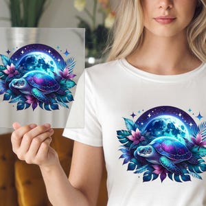 May include: A vibrant illustration of a sea turtle with a galaxy-like shell, set against a full moon and surrounded by tropical leaves and flowers. The design features shades of blue, purple, and pink, creating a dreamy, celestial theme.