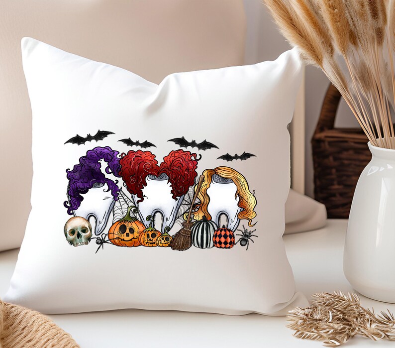 May include: White throw pillow with a Halloween-themed design featuring four cartoon teeth with witch hats and hair, bats, pumpkins, and a spider. The text "Boo" is written in black.