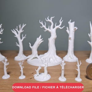 Op de afbeelding: Een verzameling van elf witte 3D-geprinte miniatuurbomen in verschillende hoogtes en vormen, met knoestige stammen en kale takken. Een munt van twee euro ligt aan de rechterkant voor schaal, wat een duidelijk referentiepunt biedt.
