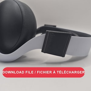 Pode incluir: Um par de auscultadores brancos e pretos com uma almofada preta texturizada e uma banda branca com um acessório retangular preto. A imagem inclui o texto DOWNLOAD FILE / FICHIER À TÉLÉCHARGER num retângulo vermelho com cantos arredondados.