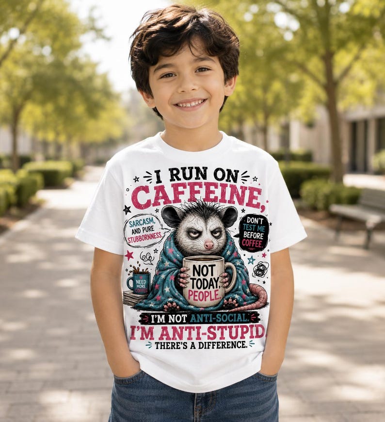 K&ouml;nnte beinhalten: Ein wei&szlig;es T-Shirt mit einer Grafik eines Opossums, das in eine blaue Decke eingewickelt ist und eine Tasse mit der Aufschrift NOT TODAY PEOPLE h&auml;lt. Der Text lautet I RUN ON CAFFEINE, SARCASM AND PURE STUBBORNESS, DON'T TEST ME BEFORE COFFEE, I'M NOT ANTI-SOCIAL. I'M ANTI-STUPID.