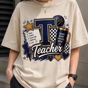 K&ouml;nnte beinhalten: Ein beiges T-Shirt mit einem Grafikdesign, das einen gro&szlig;en Buchstaben T, einen Notizblock mit einer Liste von W&ouml;rtern wie Teach, Inspire, Encourage, Motivate, Love sowie einen Becher mit dem Text EDUCATE, INSPIRE, EMPOWER, REPEAT und Teacher zeigt.