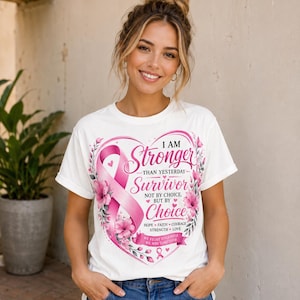 May include: White t-shirt with a pink ribbon and floral heart design. The text reads "I AM Stronger Than Yesterday Survivor Not By Choice But By Choice". The shirt also includes the words "Hope, Faith, Courage, Strength, Love" and "We Fight Together, We Win Together".