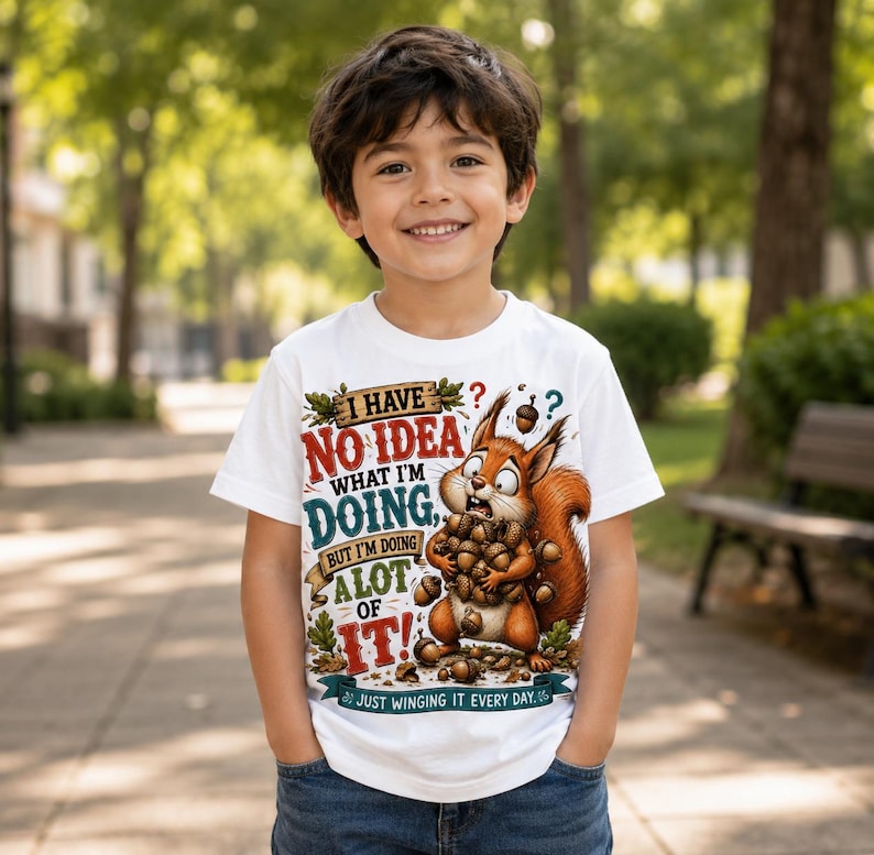K&ouml;nnte beinhalten: Ein wei&szlig;es Kurzarm-T-Shirt mit einer Grafik eines braunen Eichh&ouml;rnchens, das viele Eicheln h&auml;lt. Der Text lautet: I HAVE NO IDEA WHAT I'M DOING, BUT I'M DOING A LOT OF IT! JUST WINGING IT EVERY DAY. Das Design enth&auml;lt bunte Schriftz&uuml;ge und Eichenbl&auml;tter.