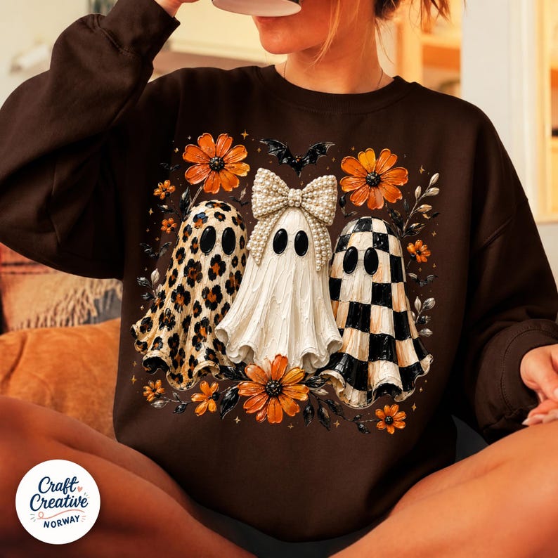 May include: A dark brown long-sleeve sweatshirt featuring a graphic print of three ghosts. The left ghost has a leopard print pattern, the center ghost wears a large pearl-embellished bow, and the right ghost has a black and white checkerboard pattern.