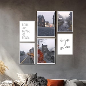 Könnte beinhalten: Eine Sammlung von sechs gerahmten Kunstdrucken. Die Drucke zeigen Landschaftsfotografien von Stadt- und Flussszenen in gedämpften Tönen sowie zwei Drucke mit Text: "The fog hides the view, not the way" und "See less & feel more".