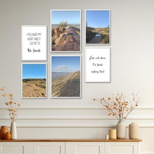Puede incluir: Cinco impresiones enmarcadas con citas e imágenes con temática de playa. Las impresiones están dispuestas en una cuadrícula en una pared blanca. La fila superior presenta una cita sobre seguir tu corazón hasta la playa y una foto de una playa de arena con un tronco de madera a la deriva. La fila del medio presenta una foto de una playa de arena con un camino que lleva al océano y una cita sobre el tiempo de caminata en la playa. La fila inferior presenta una foto de una playa de arena con hierba alta y una foto de una playa de arena con huellas.