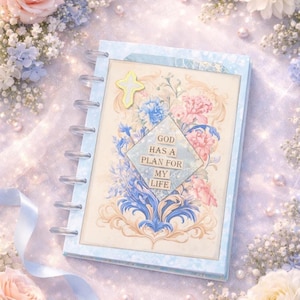 May include: A light blue planner with a floral design featuring pink and blue flowers. The planner has a diamond-shaped text box that reads "GOD HAS A PLAN FOR MY LIFE". A yellow cross is attached to the top.