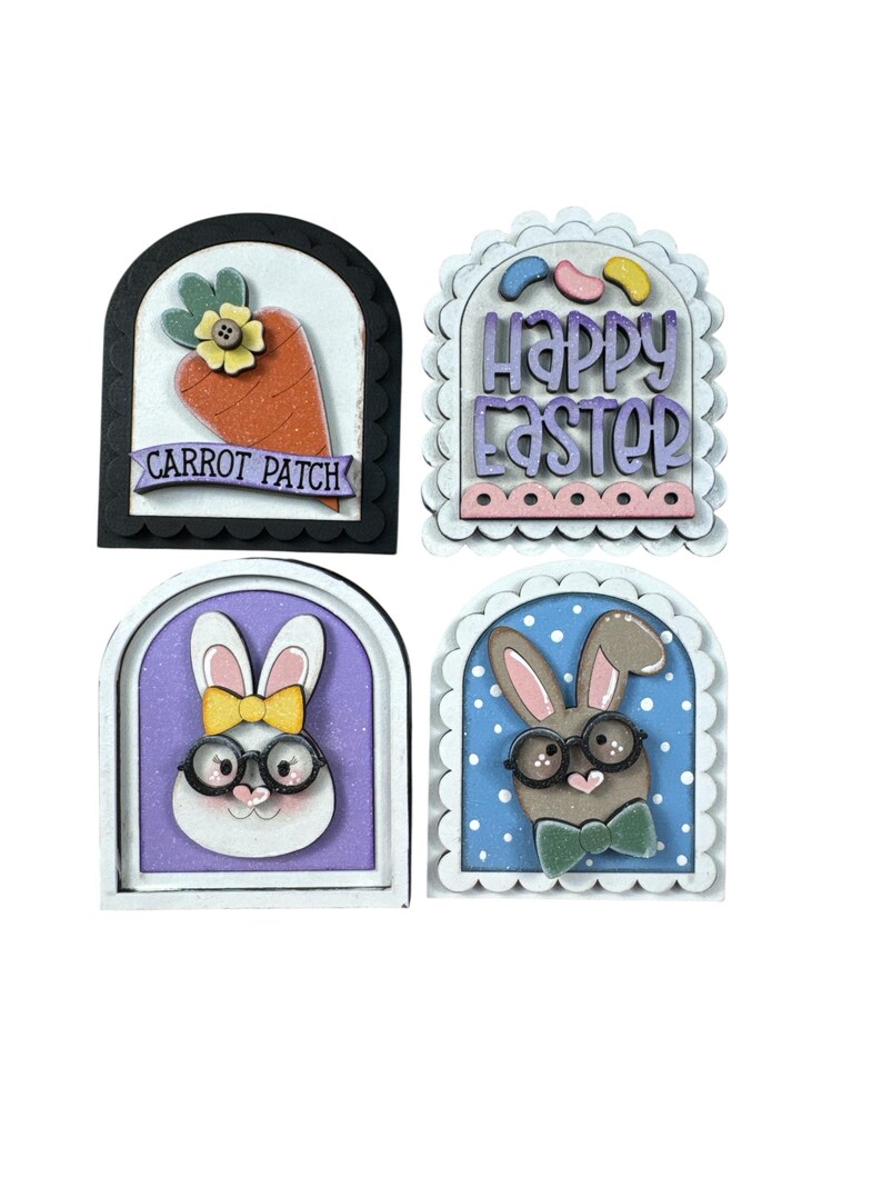 Pode incluir: Quatro decora&ccedil;&otilde;es de P&aacute;scoa em madeira. Uma apresenta uma cenoura com o texto "CARROT PATCH". Outra diz "Happy Easter". As outras duas t&ecirc;m rostos de coelho usando &oacute;culos e gravatas borboleta. Todas est&atilde;o em molduras arqueadas.