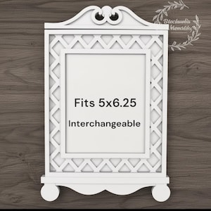 May include: White decorative picture frame with a lattice design and a decorative top. The frame is designed to fit a 5x6.25 inch photo and is interchangeable. The frame has a decorative base with two round feet.