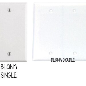 May include: Two white plastic electrical wall plates. The plate on the left is labeled "BLANK SINGLE" and the plate on the right is labeled "BLANK DOUBLE".