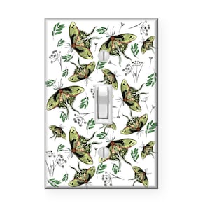 May include: A white light switch cover with a pattern of green and brown butterflies and floral designs.