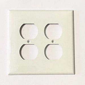 May include: White plastic electrical outlet cover with two double outlets.